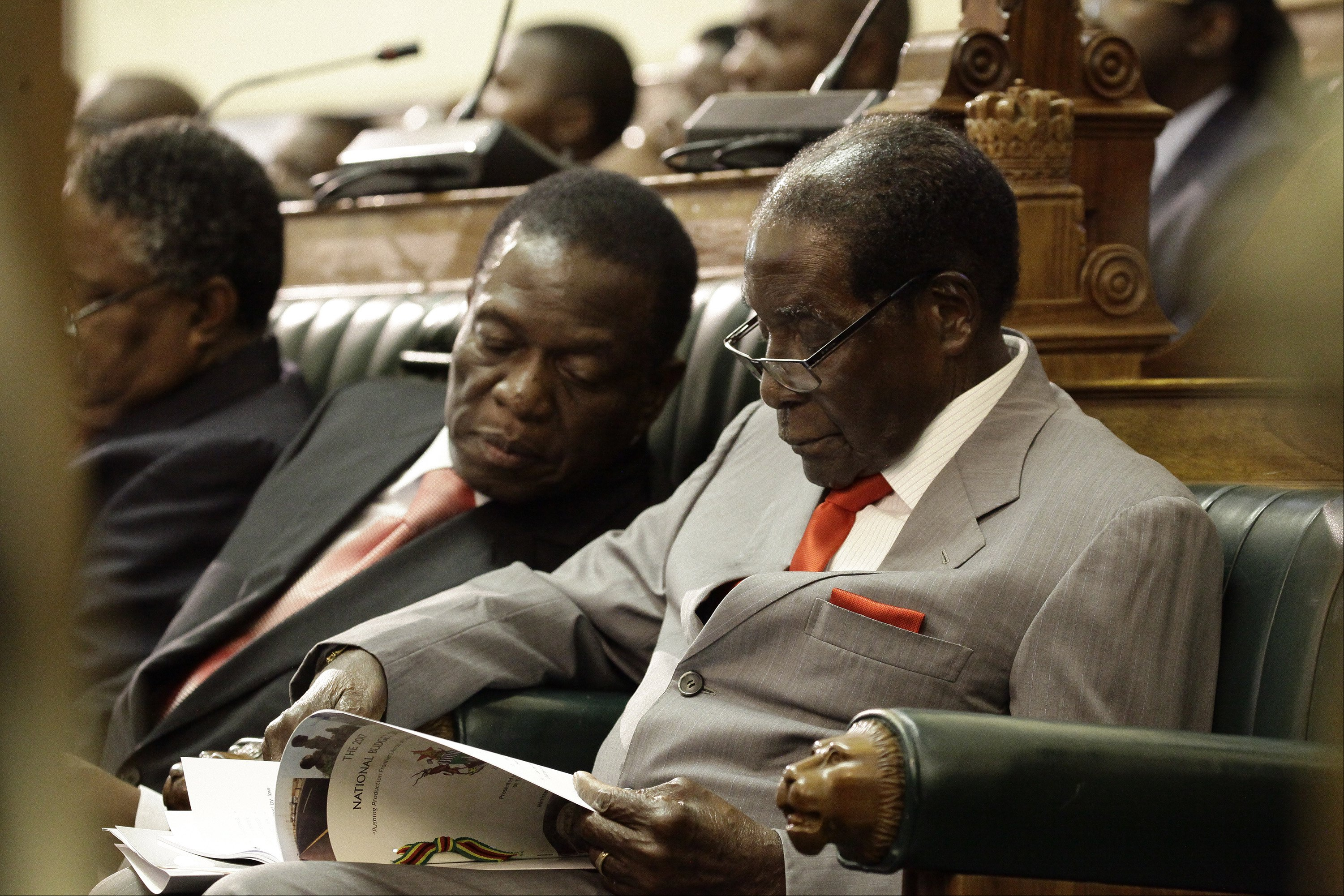 O presidente do Zimbábue, Robert Mugabe (direita), é acompanhado pelo vice-presidente Emmerson Mnangagwa (esquerda), na Câmara do Parlamento, em Harare - Foto Agência Lusa